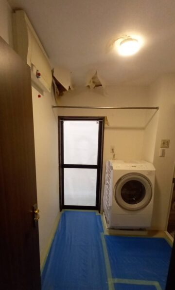 alt="【愛知県名古屋市】洗面リフォーム 施工前 天井からの水漏れにより壁紙が剥がれて傷んでいる洗面所の状態"