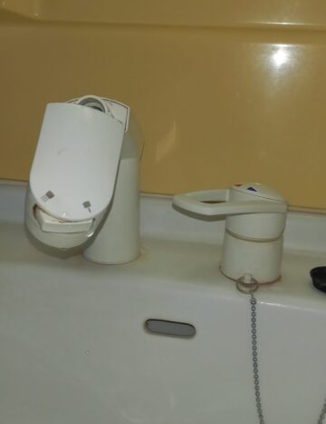 alt="【岐阜県各務原市】洗面化粧台水栓取替工事 施工前 洗面化粧台の水栓が劣化し水漏れが発生している状態"